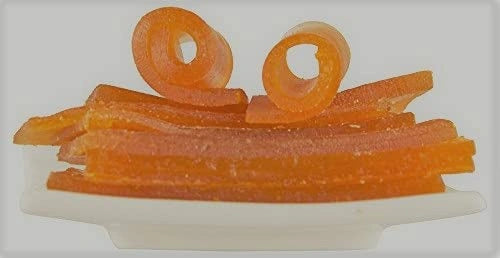 Orange gummy candy on a white plate with a white background