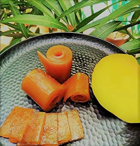 Carrot sticks on a textured plate with a lemon and green leaves in the background